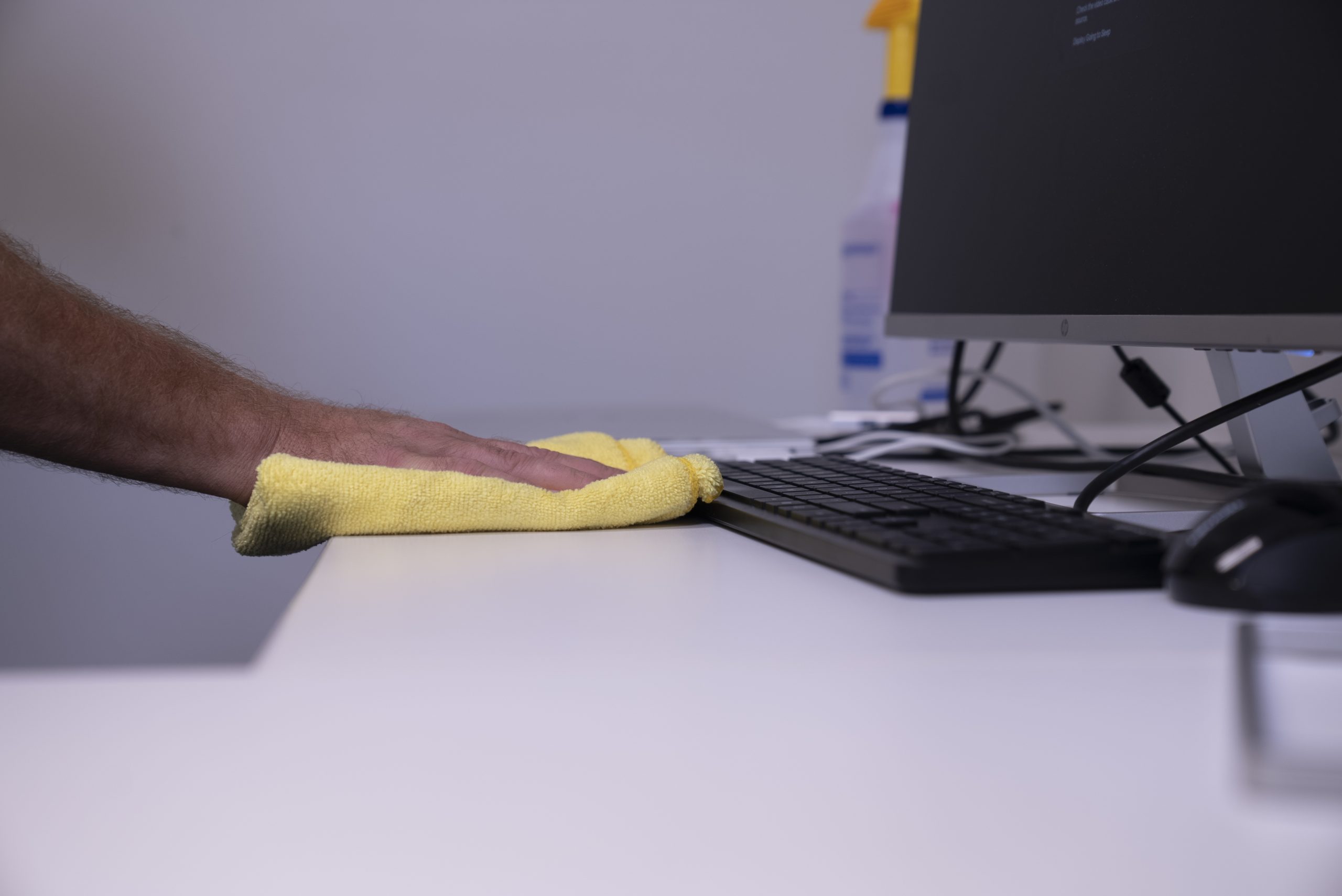 Wiping down an office desk Wiping down an office desk